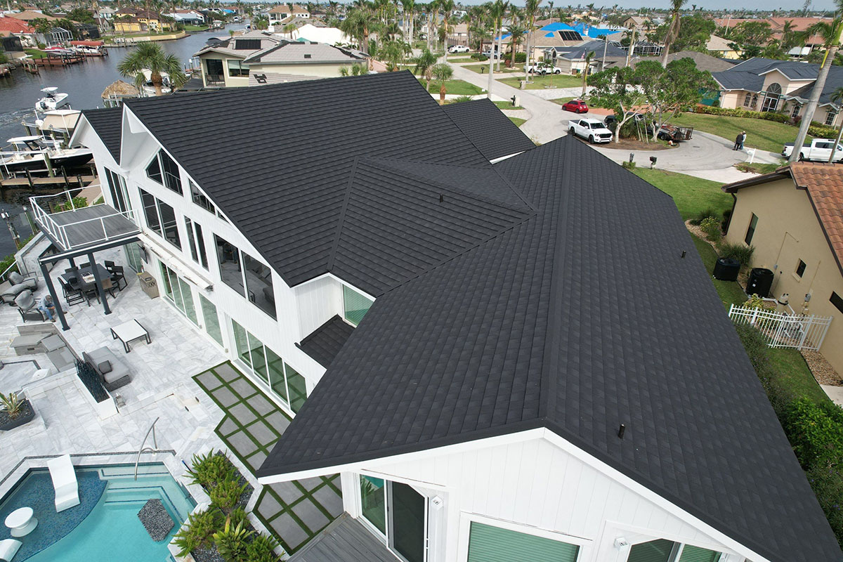 Aerial view of white home with dark Tilcor CF shingles installed