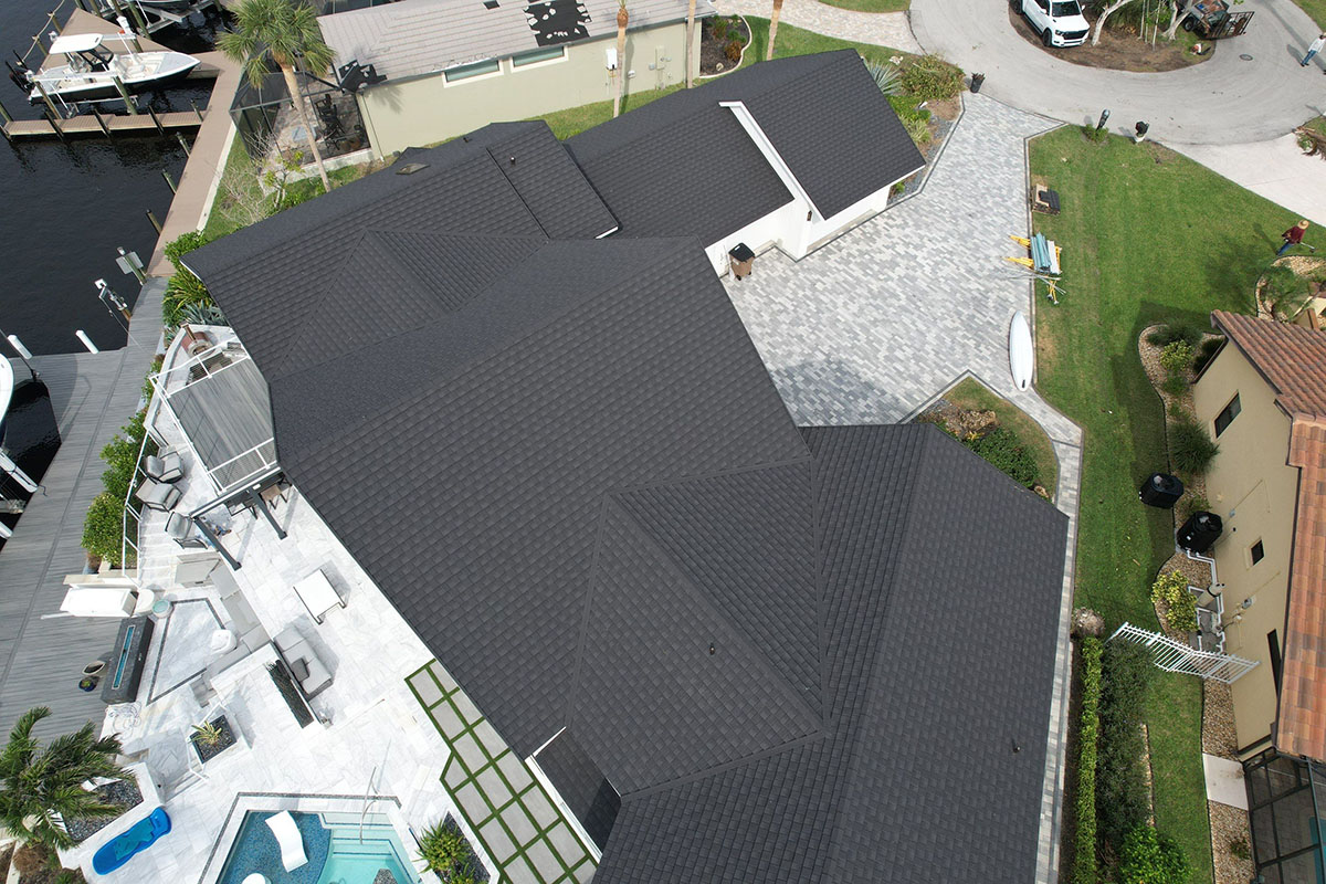 Aerial view of white home with dark Tilcor CF shingles installed