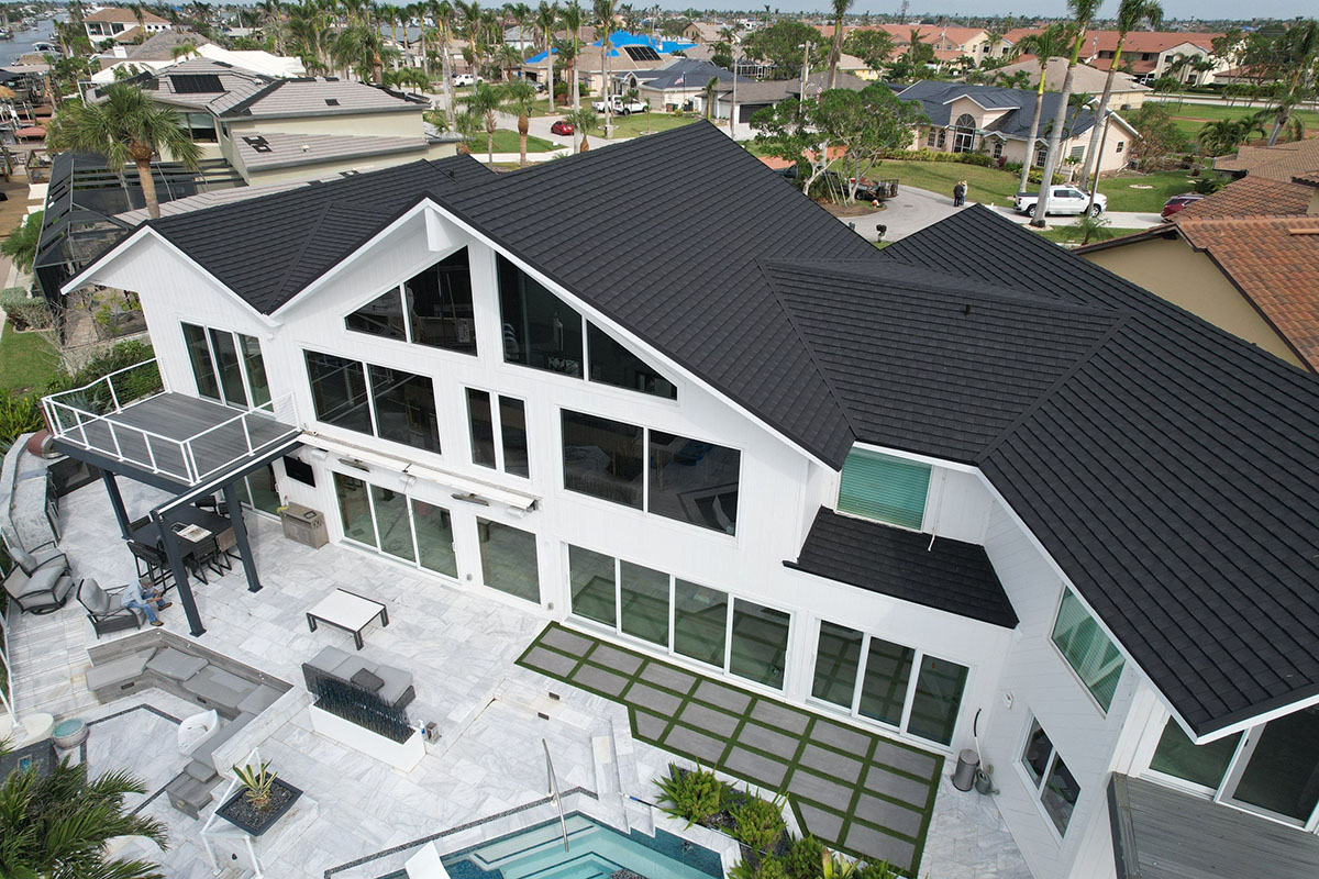 Aerial view of white home with dark Tilcor CF shingles installed